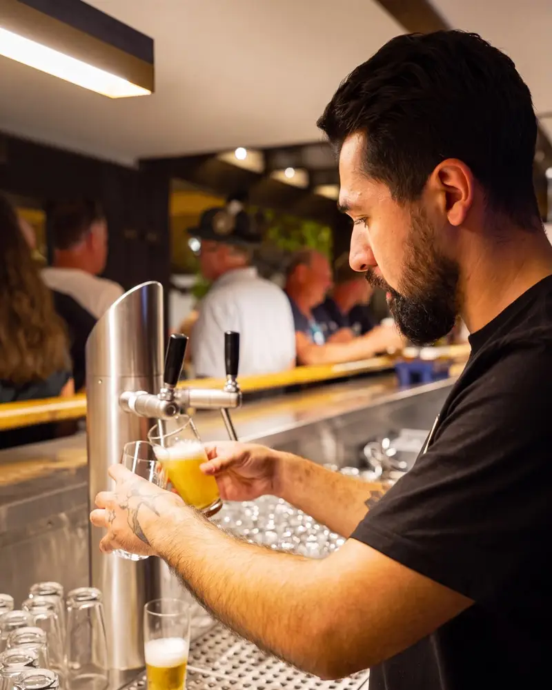 Mustafa Yildirim, Inhaber von Frankies Eventservice, zapft Bier an der Theke